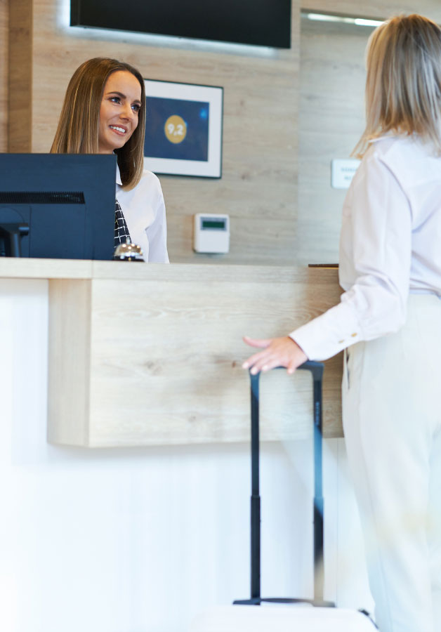 Traveller checking into hotel at guest services counter