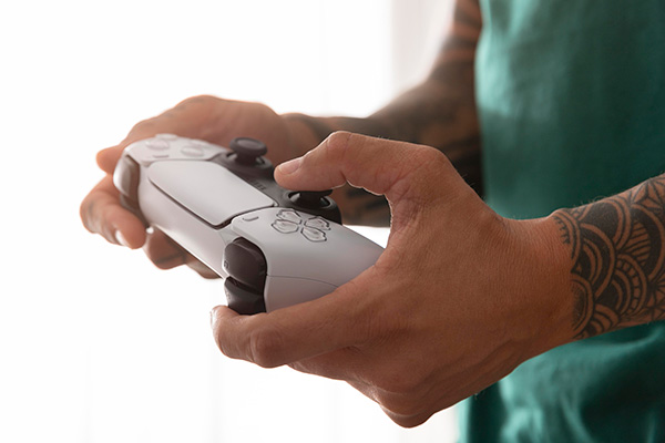 closeup of man playing video games with hands on controller