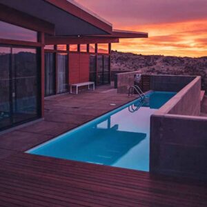 sunset photo of outdoor vacation rental with pool overlooking mountains
