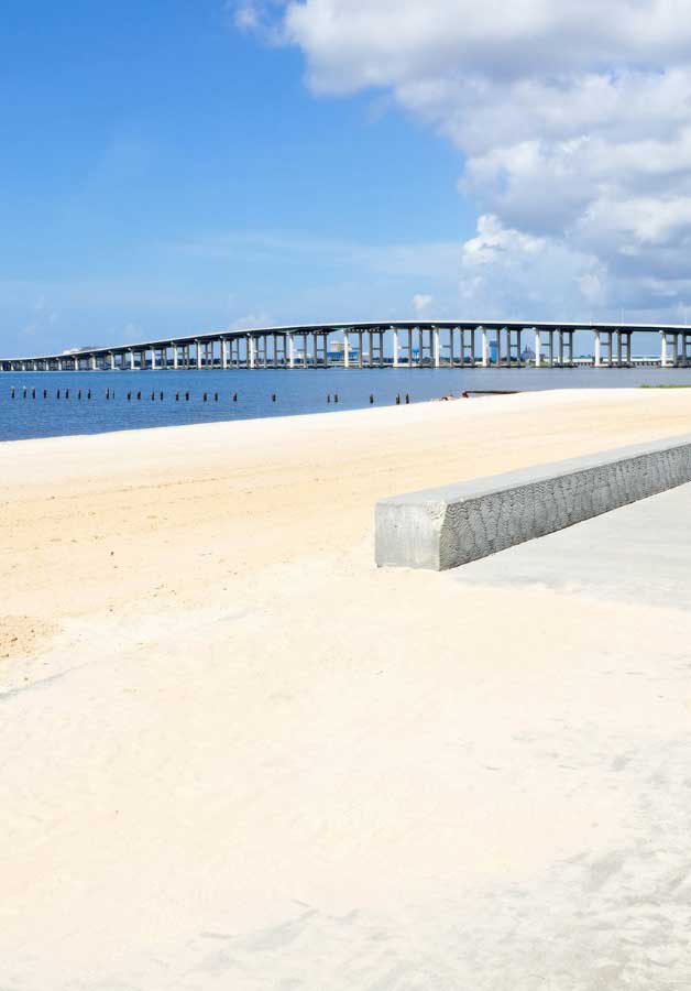 view of the beach in Ocean Springs with bridge in background