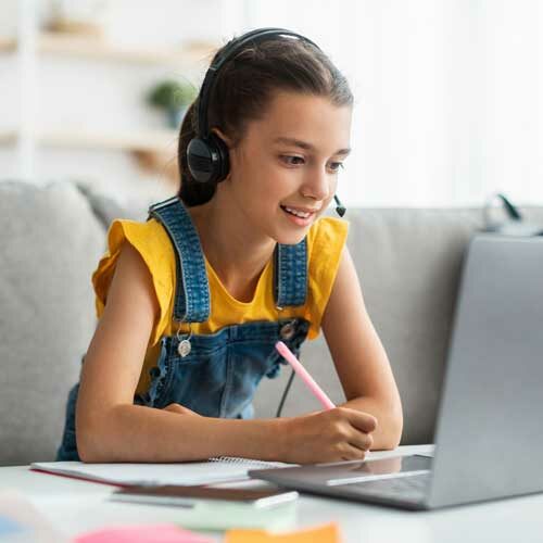 school-aged girl on laptop attending virtual school remotely